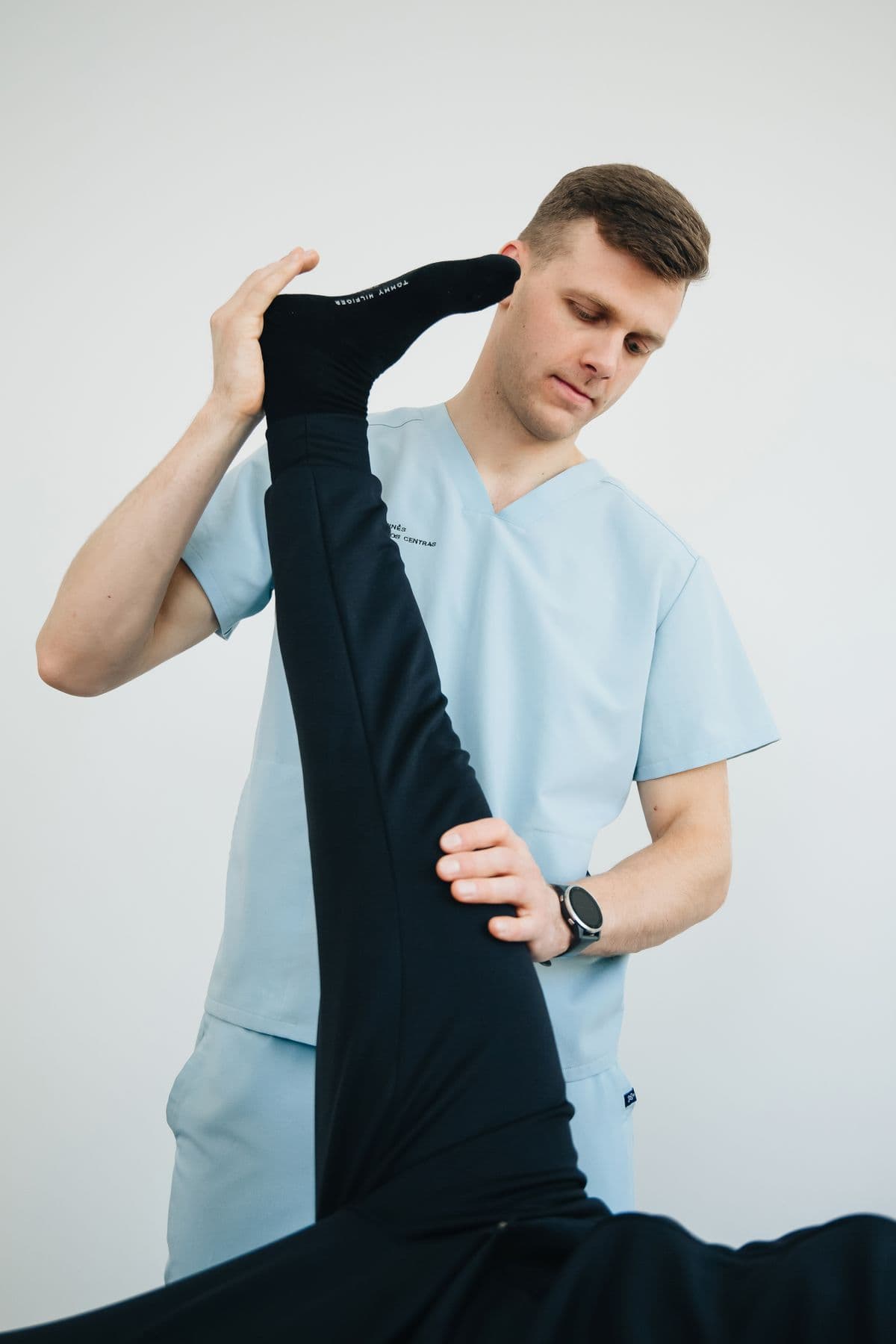 Physiotherapist lifting a patient's straight leg during a stretch