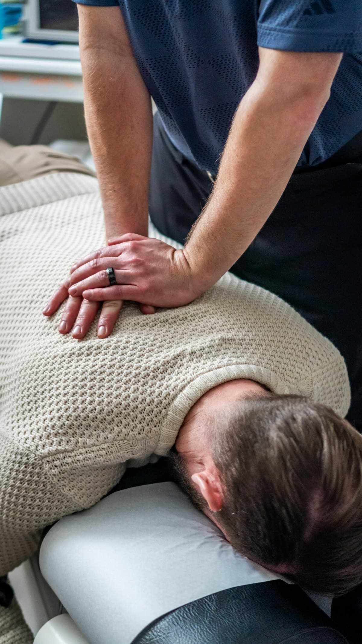 Therapist applying manual therapy to a patient's upper back